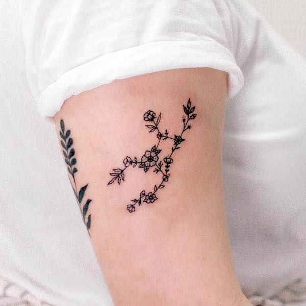 Tatuajes florales de la constelación de Virgo en el brazo por @nuhfun