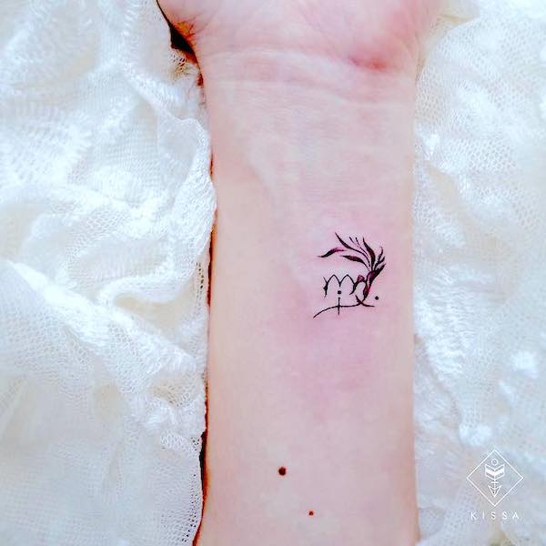 Un tatuaje del símbolo de Virgo en la muñeca realizado por @kissa.tattoo