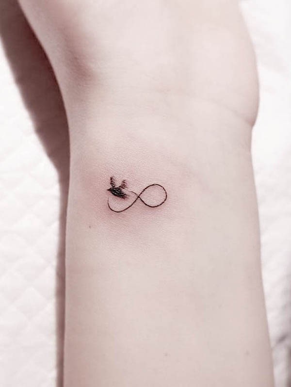 Small and simple infinity bird tattoo by @wittybutton_tattoo