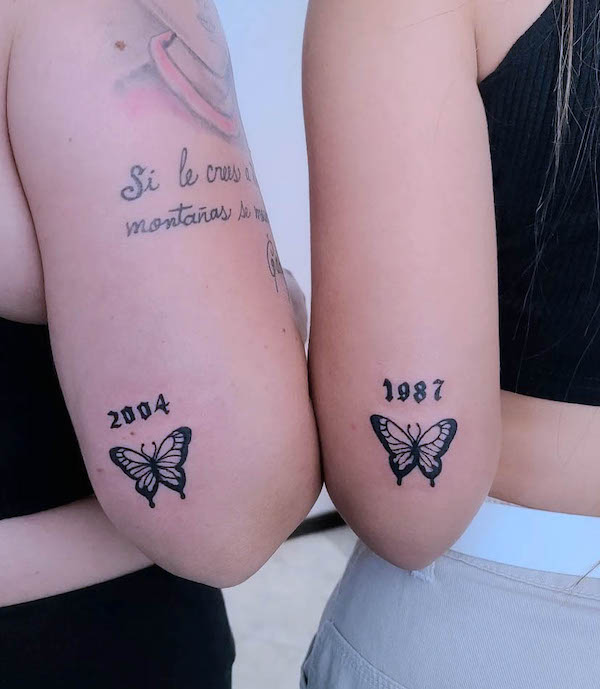Butterfly with year of birth mother daughter tattoos by @dark.arts_tattoo