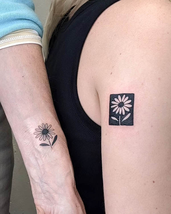 Matching flowers mother daughter tattoos by @molebulle