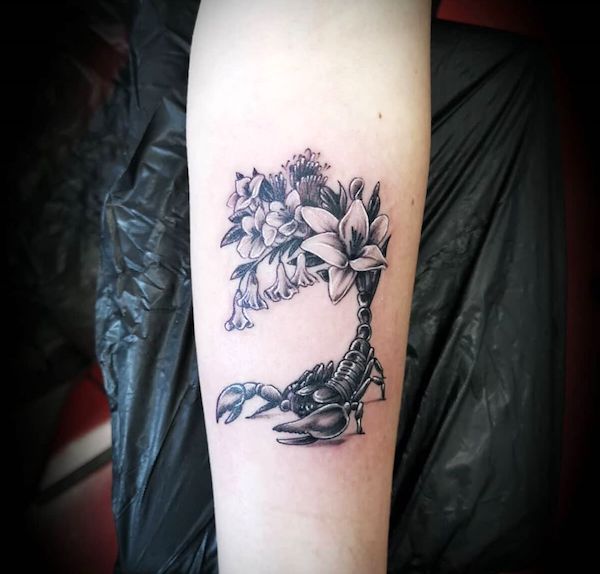 A Scorpio tattoo with flowers by @el_loco_tat2 - Scorpio tattoos for women that are pure dark aesthetics
