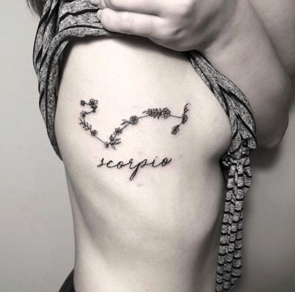 A floral constellation rib tattoo by @blackfoxtattoobp