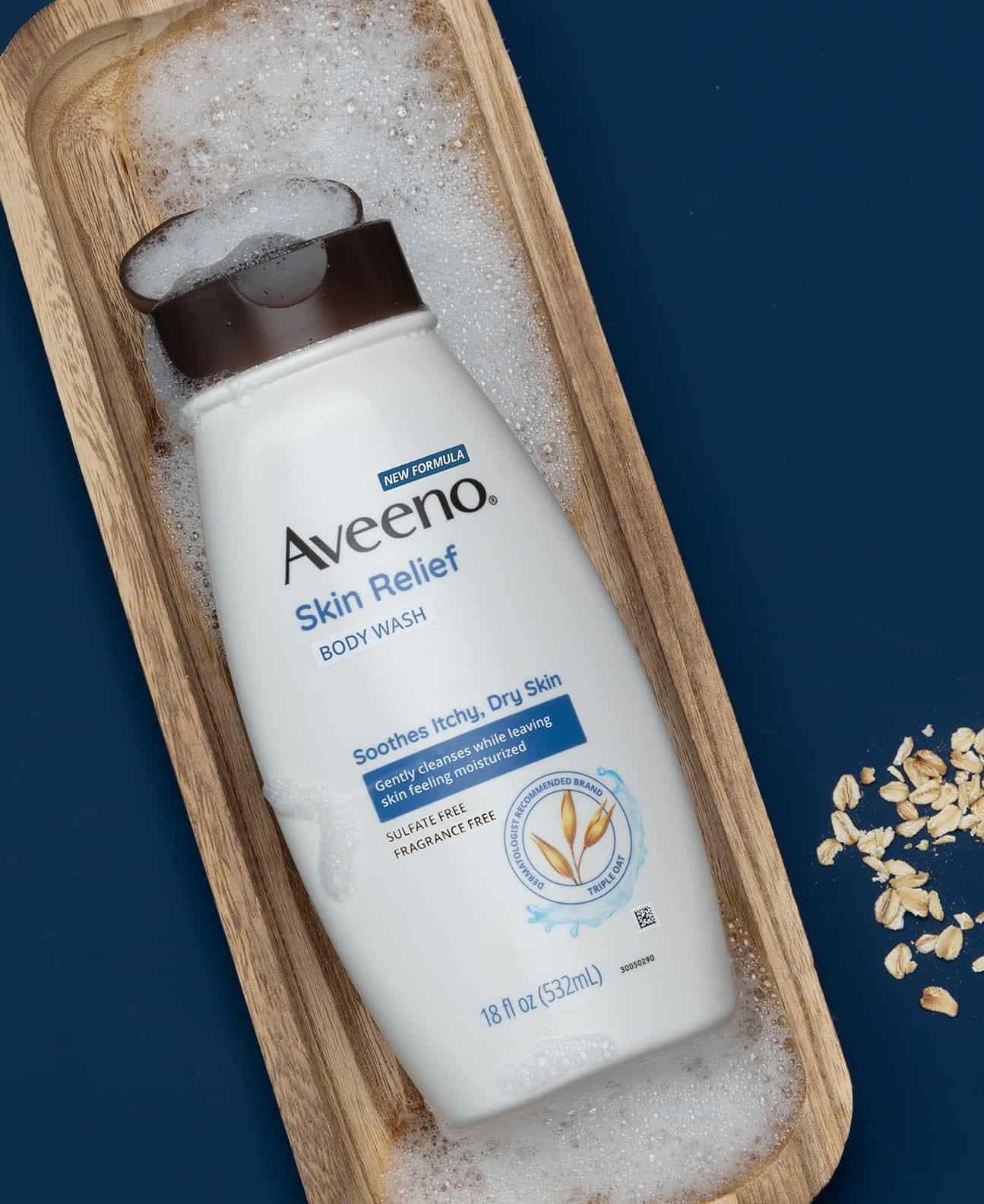 a bottle of skin relief body wash by aveeno on a wooden tray