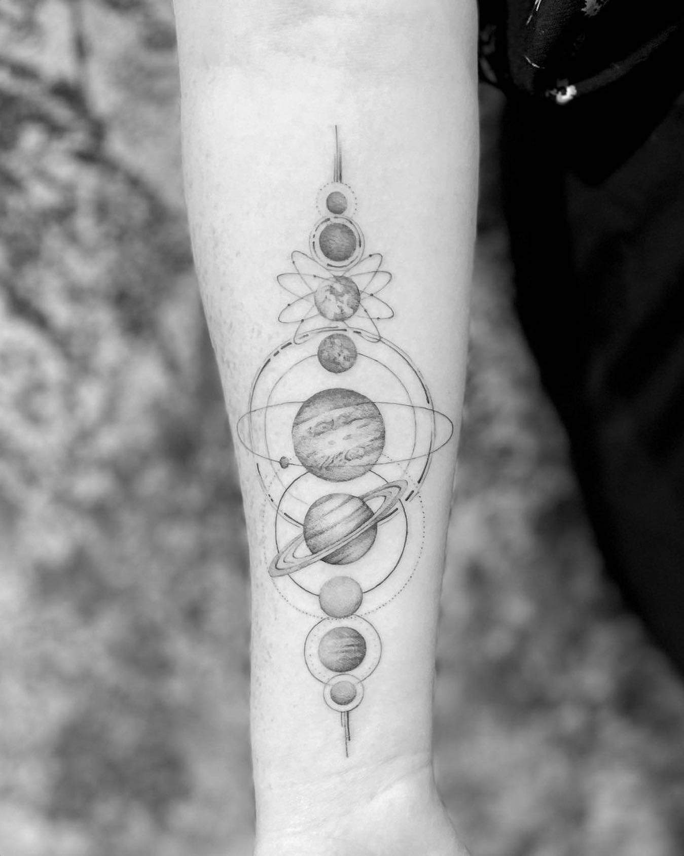 Tatuaje del sistema solar en el brazo.